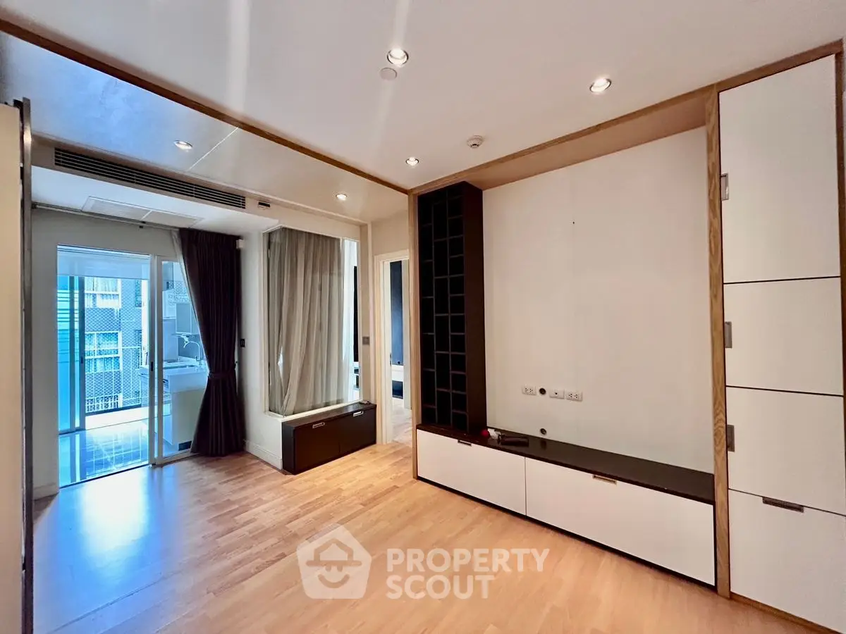 Spacious modern living room with wooden flooring and balcony access