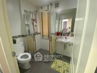 Modern bathroom with glass shower and sleek fixtures in a stylish home.