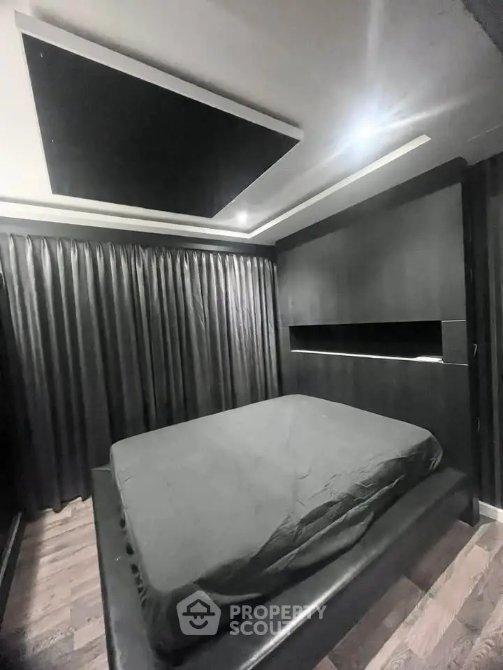 Modern bedroom with sleek black design and ambient lighting