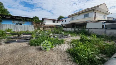 Spacious residential plot with potential for development, surrounded by existing homes and greenery.