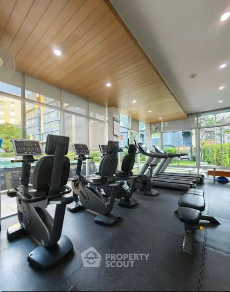 Modern gym with state-of-the-art equipment and large windows offering garden views.