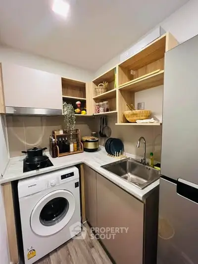 Modern compact kitchen with washing machine and sleek cabinetry