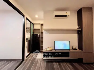 Modern living room with sleek design and integrated kitchen area, featuring air conditioning and stylish flooring.