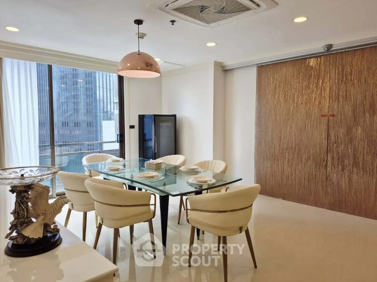 Elegant dining area with glass table and city view, perfect for modern living.