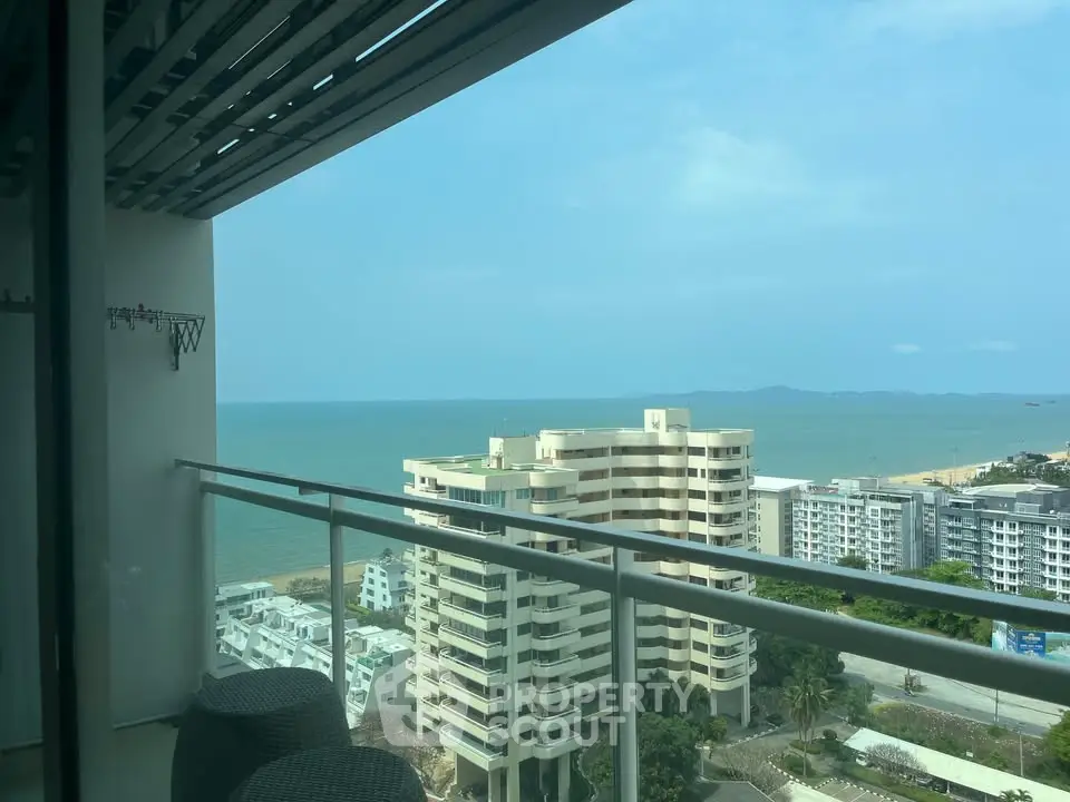 Stunning ocean view from high-rise balcony with modern railing and seating area.