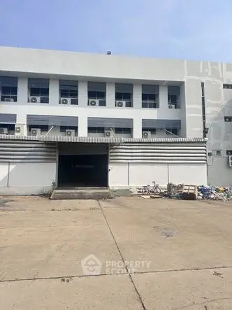 Industrial warehouse exterior with loading dock and parking area