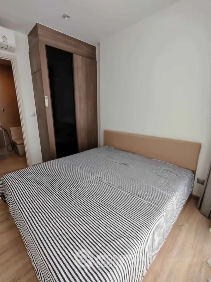Cozy bedroom with modern wardrobe and striped bedding in a stylish apartment.