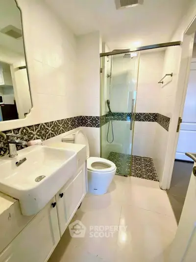Modern bathroom with elegant tile design and glass shower enclosure