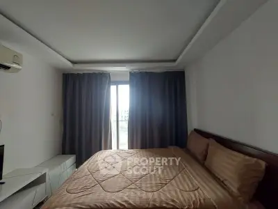 Cozy bedroom with large window and modern furnishings in a stylish apartment.