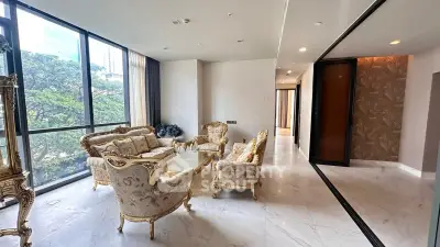 Luxurious living room with elegant furniture and large windows offering a stunning view of greenery.