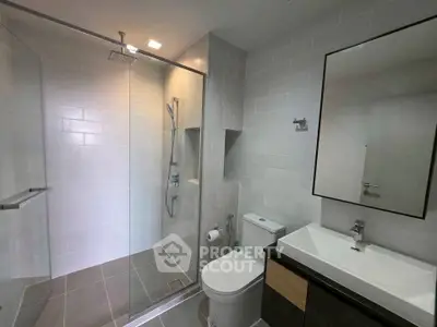Modern bathroom with glass shower and sleek fixtures in a contemporary home.