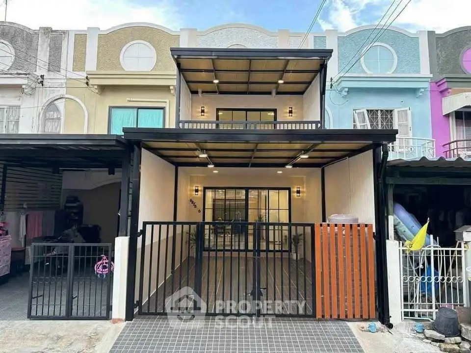 Charming two-story townhouse with modern facade and gated entrance, perfect for urban living.