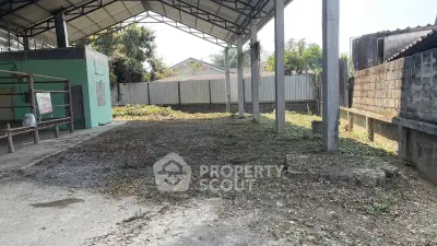 Spacious outdoor area with covered structure, ideal for storage or workshop use.