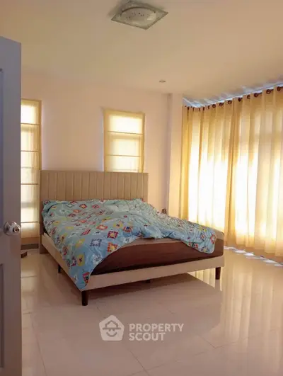 Bright and cozy bedroom with large windows and modern decor