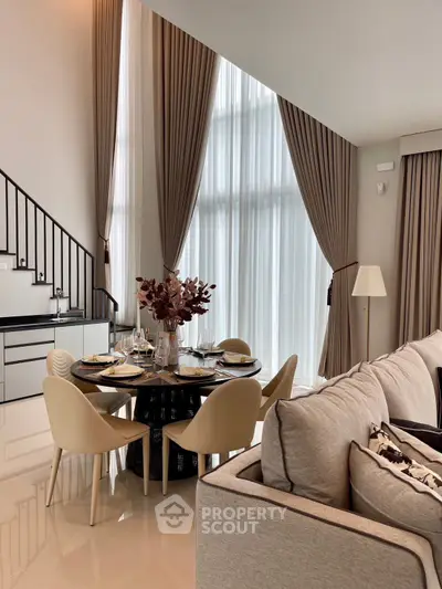 Luxurious modern living room with high ceilings and elegant dining area.