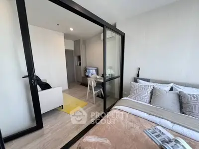Modern apartment with glass partition, cozy bedroom, and stylish living area.