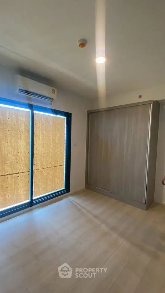 Modern bedroom with built-in wardrobe and large window with blinds