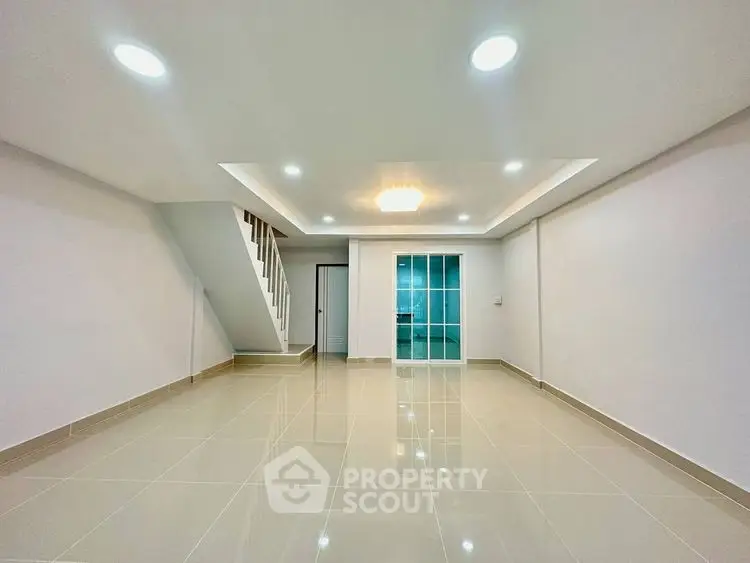 Spacious modern living room with glossy tiled floors and recessed lighting