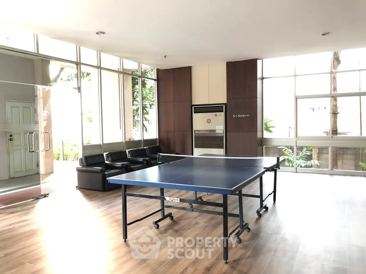Spacious recreational area with ping pong table and seating in modern building