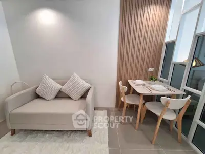 Modern living room with cozy sofa and elegant dining area near large windows.