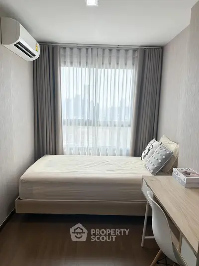 Cozy bedroom with modern decor and city view, featuring a comfortable bed and study desk.