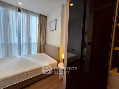 Modern bedroom with large window and stylish decor in a contemporary apartment.