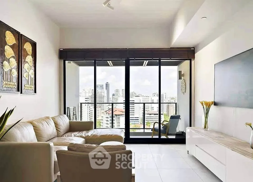 Spacious living room with modern decor and stunning city view from large windows.