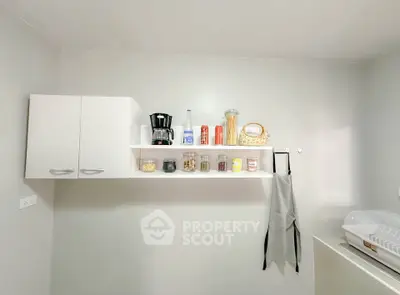 Modern kitchen with sleek white cabinets and open shelving, showcasing a minimalist design.