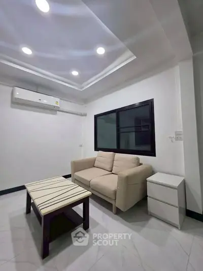 Modern living room with cozy sofa and sleek coffee table, perfect for relaxation.