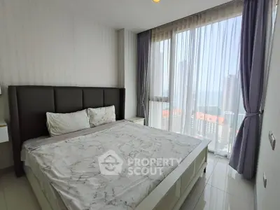 Spacious bedroom with floor-to-ceiling windows offering stunning city views in a modern high-rise apartment.