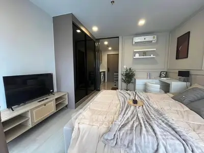 Modern bedroom with stylish decor and integrated workspace, featuring a cozy bed and sleek TV setup.