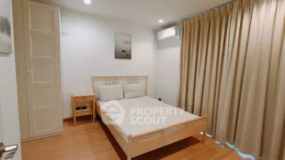 Cozy bedroom with wooden flooring and modern air conditioning unit