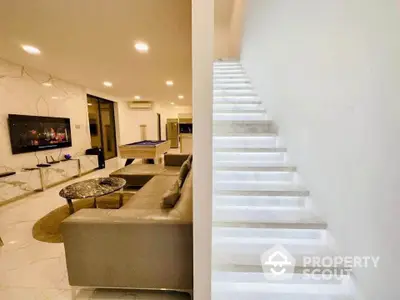 Luxurious modern living room with sleek staircase and entertainment area