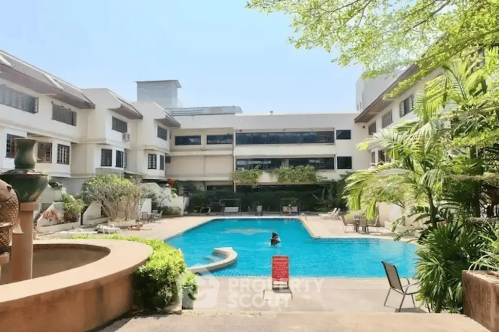 Luxurious apartment complex with inviting pool and lush greenery