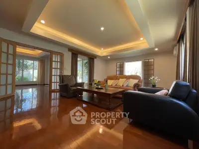 Spacious living room with elegant wooden flooring and cozy seating area.
