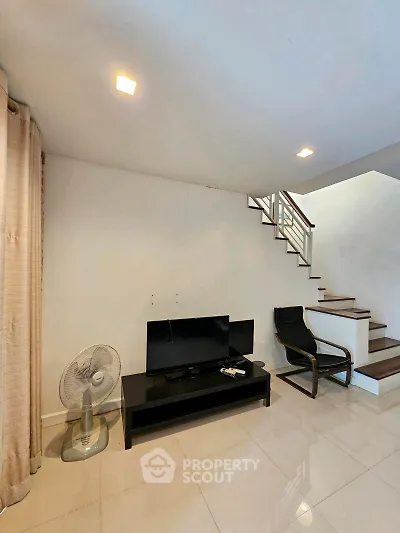 Modern living room with sleek staircase and minimalist decor