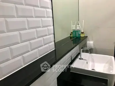 Modern bathroom with sleek black countertop and white subway tiles