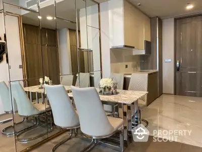 Modern dining area with elegant marble table and mirrored wall in luxury apartment