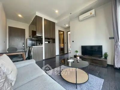 Modern living room with sleek furniture and open kitchen layout in a stylish apartment.