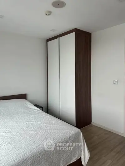 Modern bedroom with sleek wardrobe and cozy bed in minimalist design.