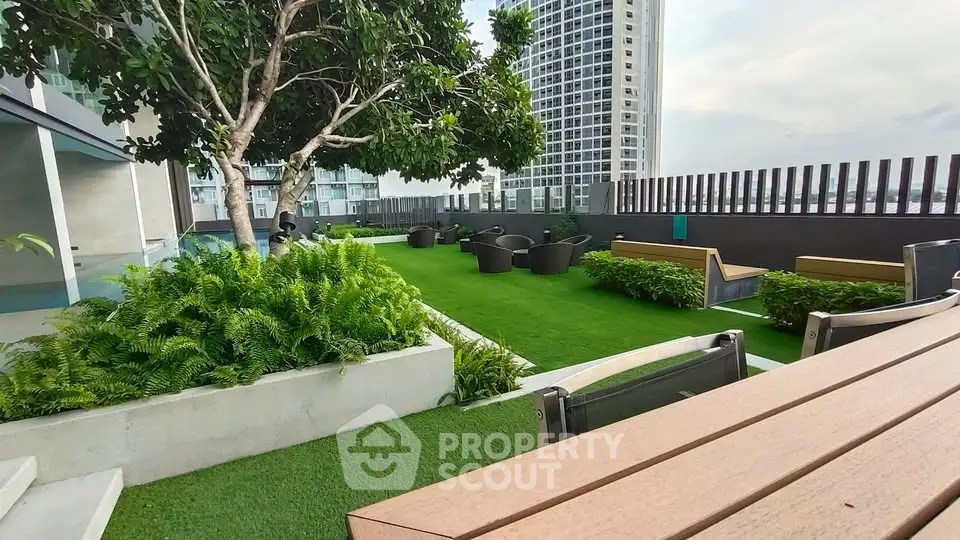 Luxurious rooftop garden with modern seating and lush greenery in a high-rise building.