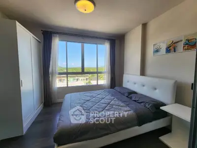 Spacious bedroom with large window offering scenic views and modern furnishings.