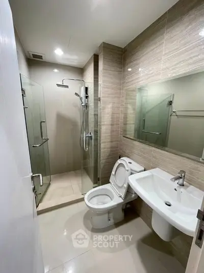 Modern bathroom with glass shower and sleek fixtures in a contemporary apartment.