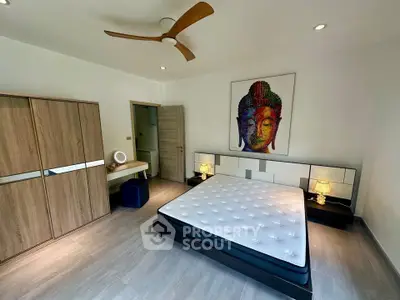 Modern bedroom with stylish decor and ceiling fan, featuring a large bed and wooden wardrobe.