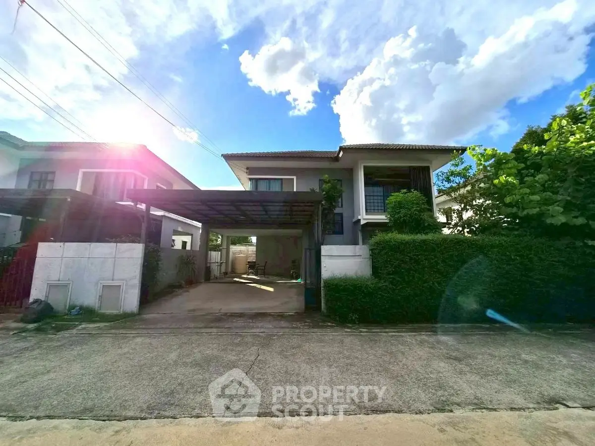 Charming two-story house with carport and lush greenery in a serene neighborhood.