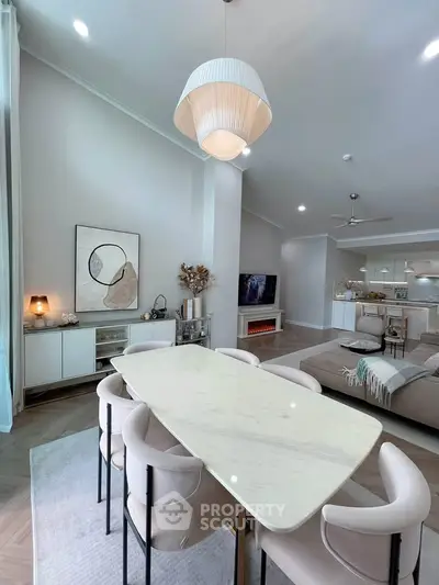Elegant open-plan living and dining area with modern decor and stylish lighting