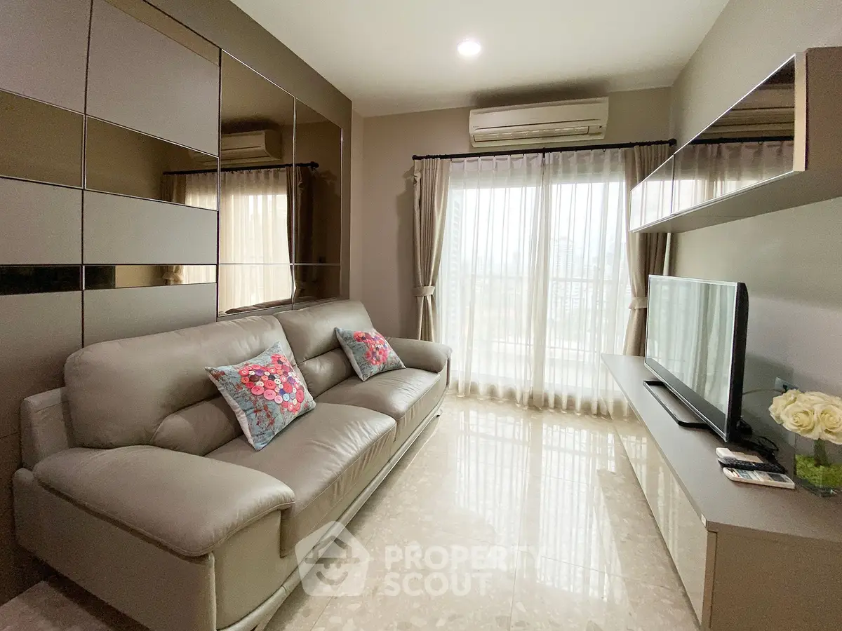 Modern living room with sleek furniture and large windows offering natural light.