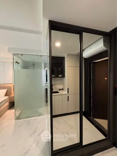Modern apartment interior with sleek kitchen and mirrored closet doors