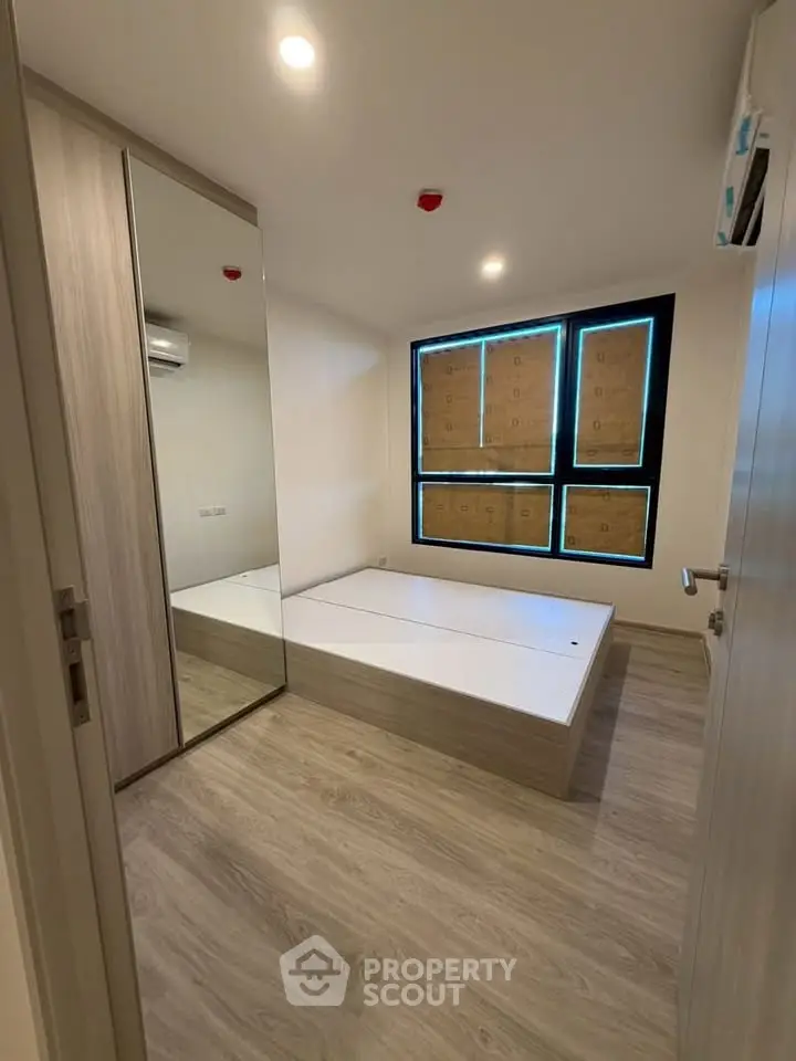 Modern bedroom with wooden flooring and built-in wardrobe in a cozy apartment.