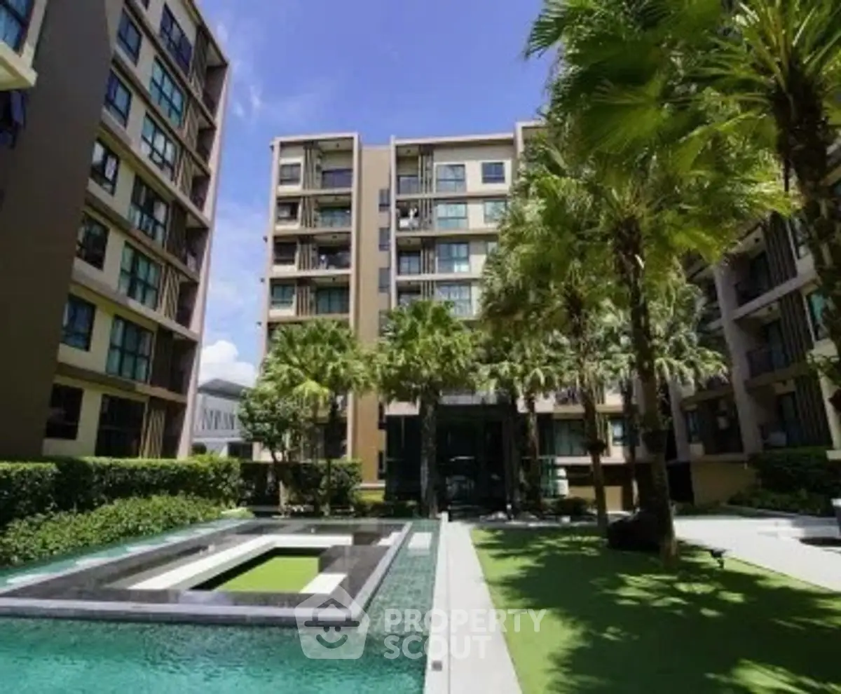 Modern apartment complex with lush garden and pool area